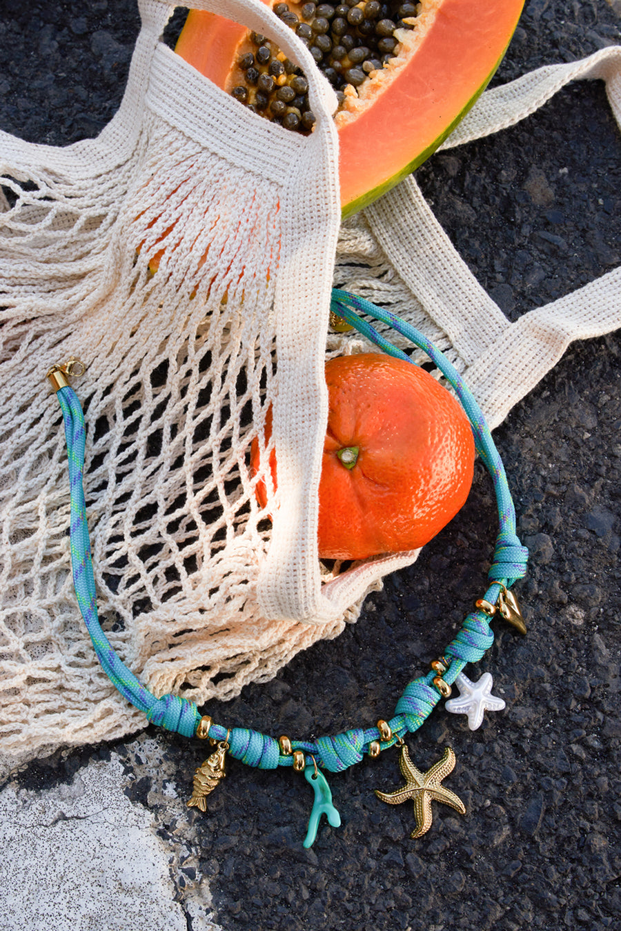 Detail van blauwe touwketting met zeesterren en koraalmotief